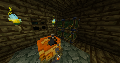 a small room, with an orange cauldron sitting in front of four cages with geckos inside them
