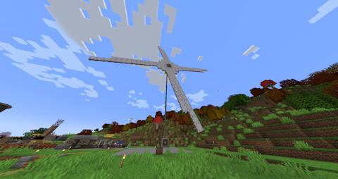 a large windmill with woolen sails spins, directing power down a shaft